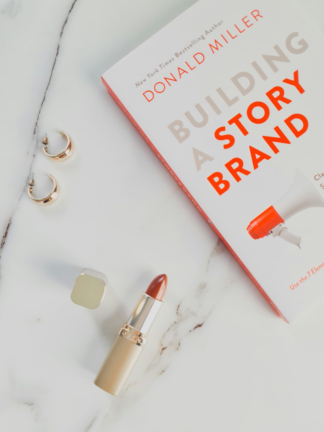 a-book-and-lipstick-on-a-marble-table-pv8xbwpph3u